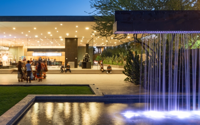 The Phoenix Art Museum with a fountain in front of a building with people walking around